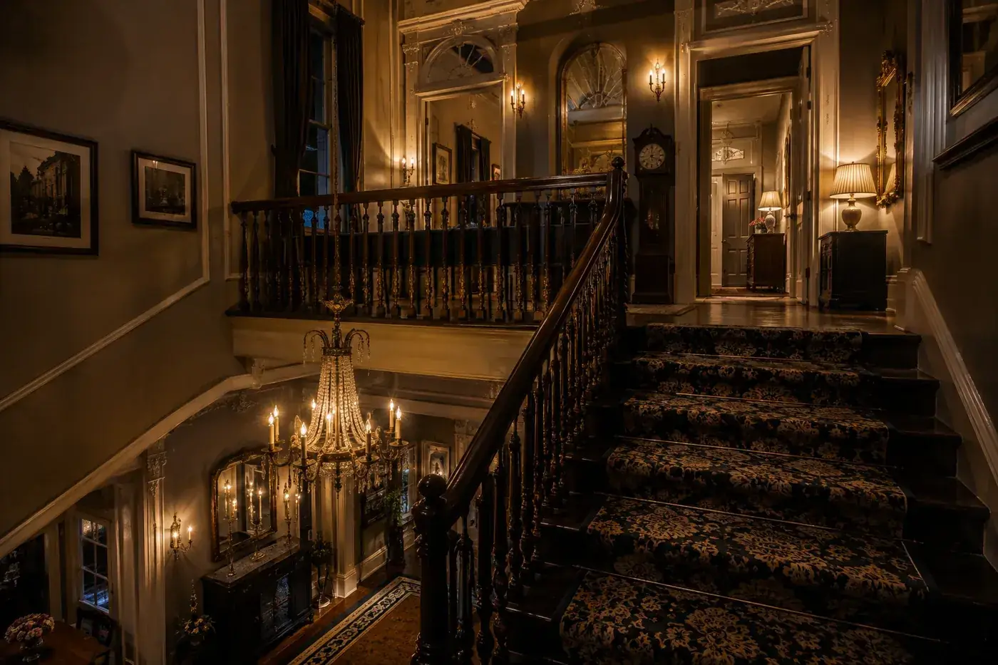 Historic staircase and upper hallway inside a Savannah mansion at night.